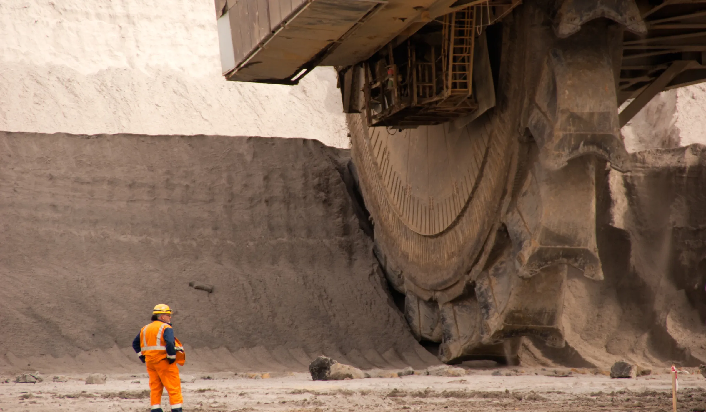 Man standing at the base of a mining vehicle