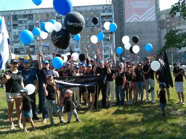 picture of celebrating people in a park with balloons