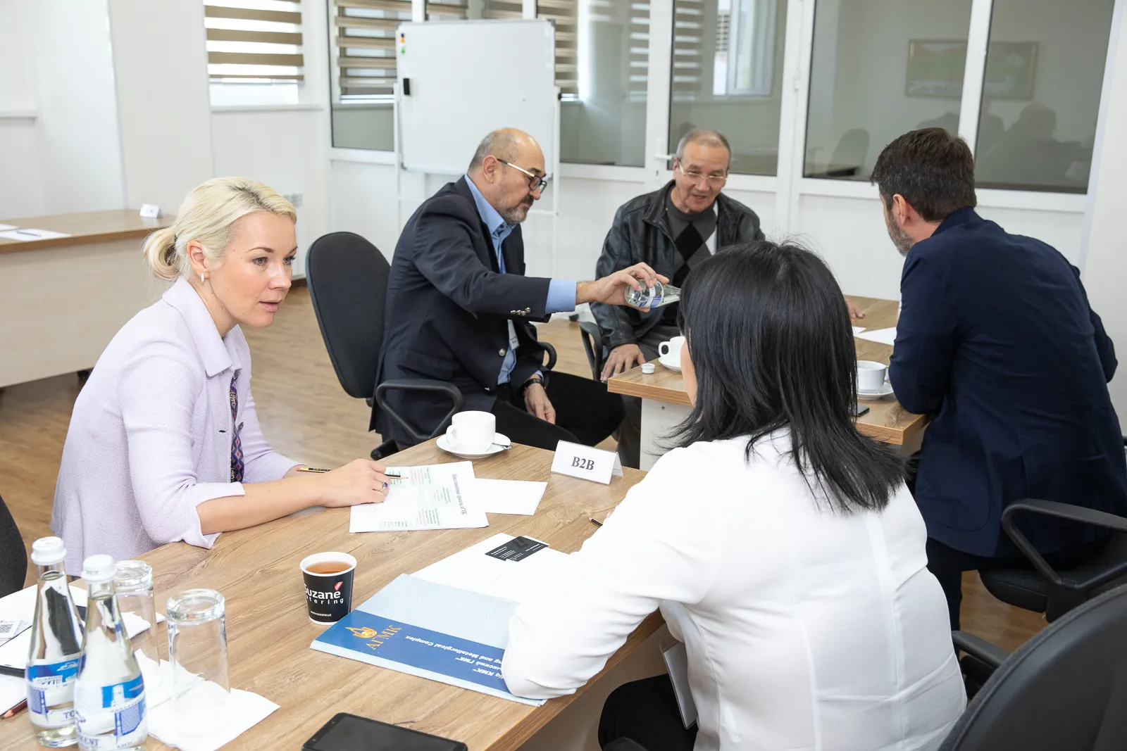 Group of people sitting on desks in a business meeting