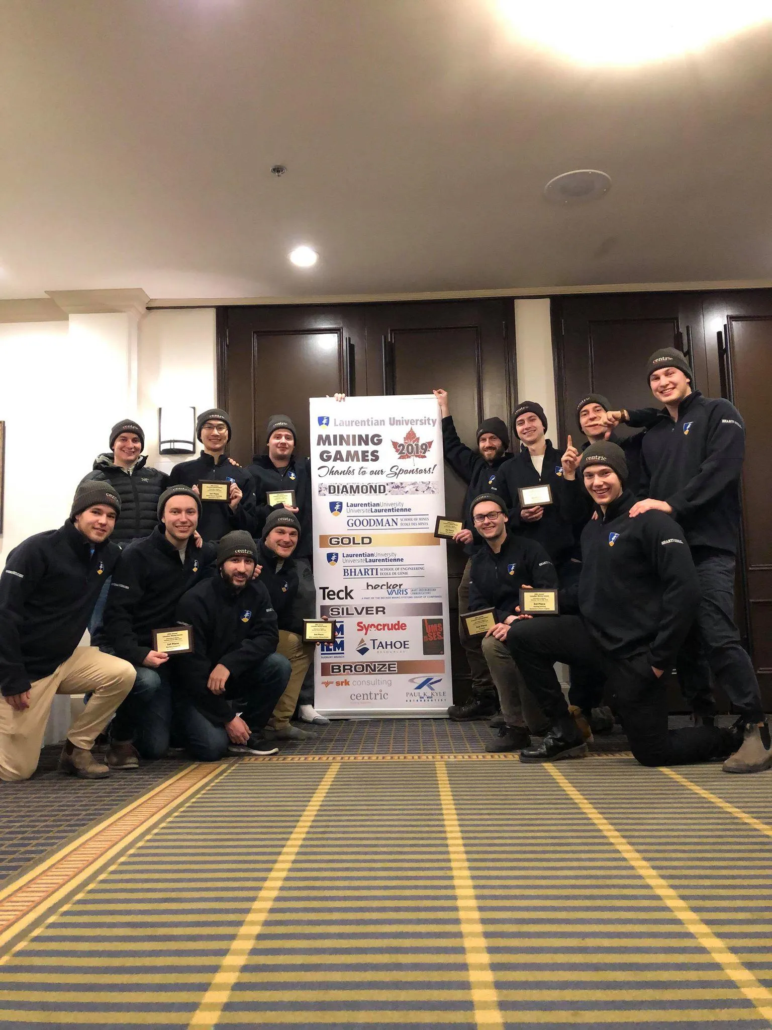 Team picture with event banner and logo